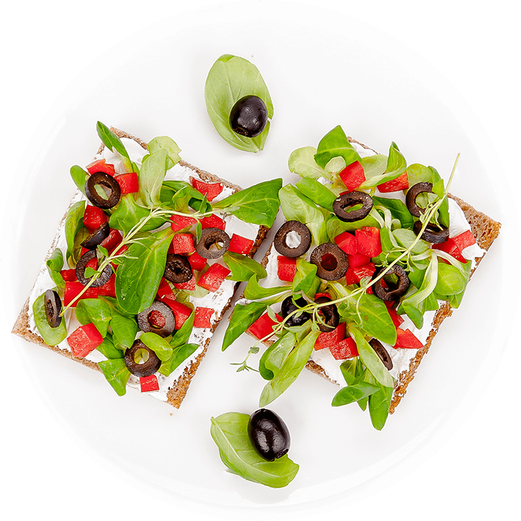 Sandwich with goat’s cheese, lamb’s lettuce, pepper and olives
