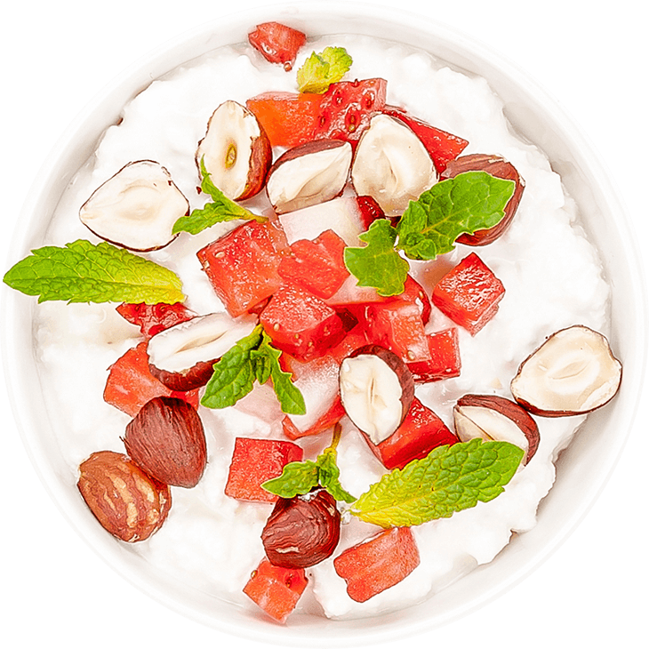 Cottage white cheese with strawberries, hazelnuts and mint