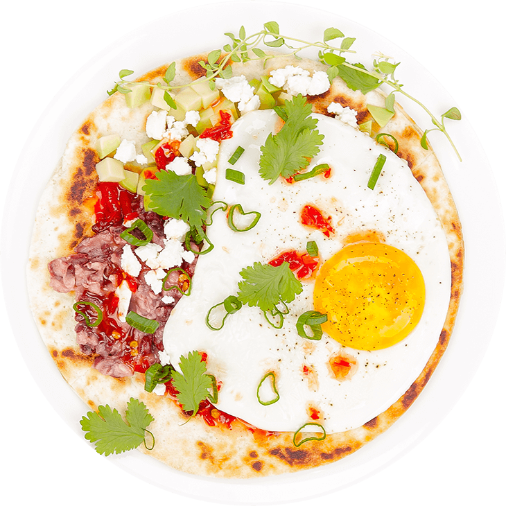 Tortilla wrap with fried eggs, beans, avocado and feta cheese